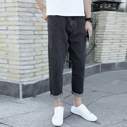 Men's black harem jeans with loose straight fit and straight leg design on a hanger