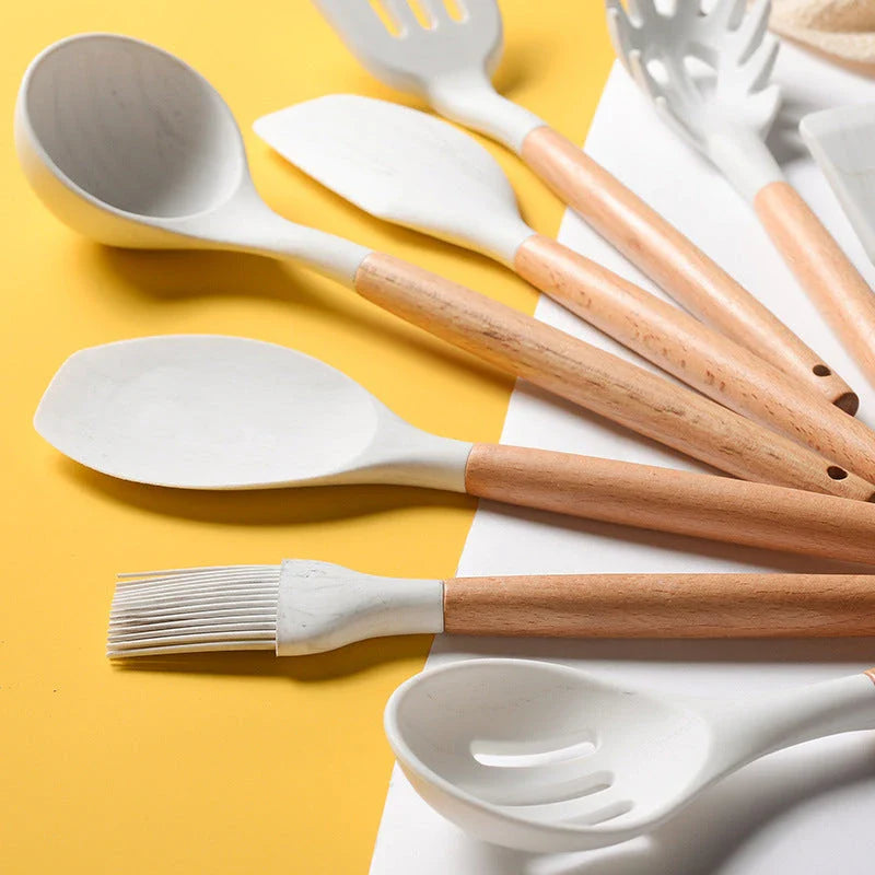 A set of silicone cooking utensils with sturdy wooden handles, designed to withstand high heat up to 446°F.