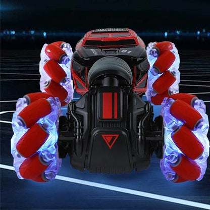 Red 4WD RC stunt car performing sideways drift with LED lights illuminated, showing gesture remote control