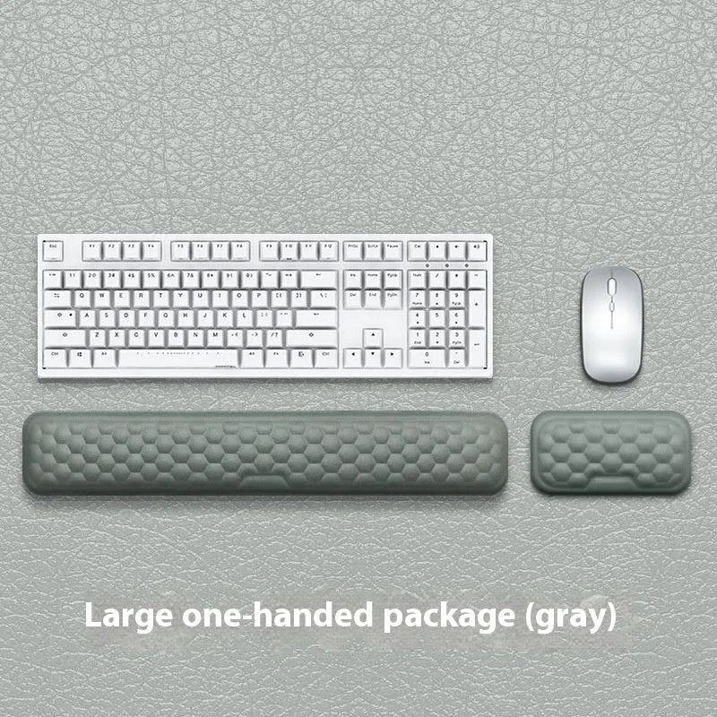 Black and grey memory foam mouse wrist rests with cloth and leather-style covers on a desk.