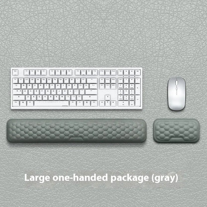 Black and grey memory foam mouse wrist rests with cloth and leather-style covers on a desk.