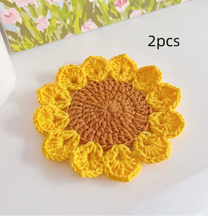 Hand-woven wool flower coaster on a wooden table