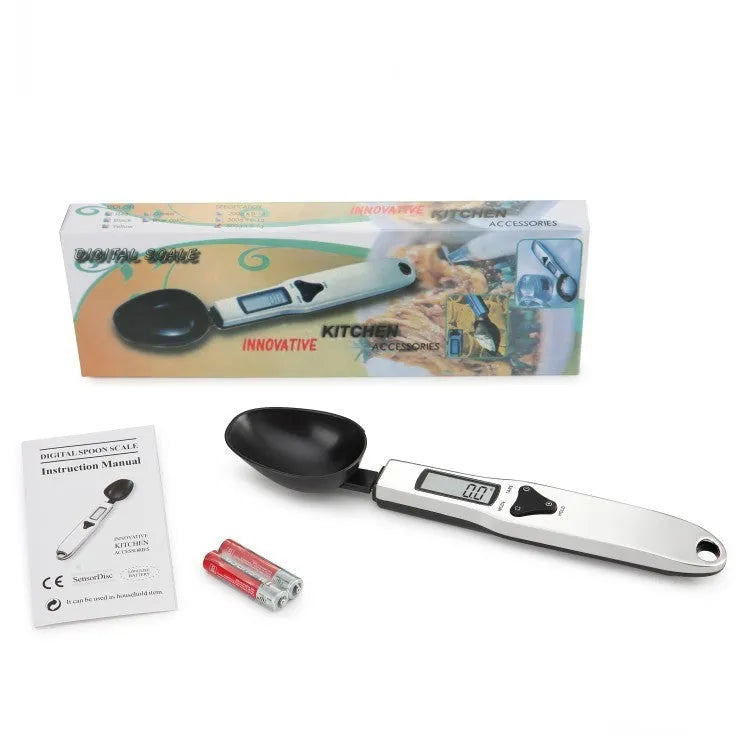Smart digital measuring spoon with electronic display showing weight, alongside two AAA batteries.