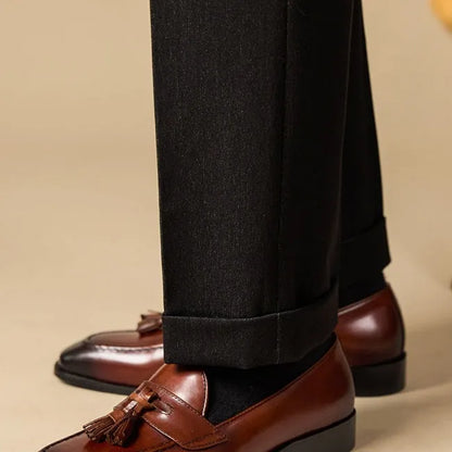 Men's black genuine leather tassel loafers with a rubber sole, shown from a side angle.