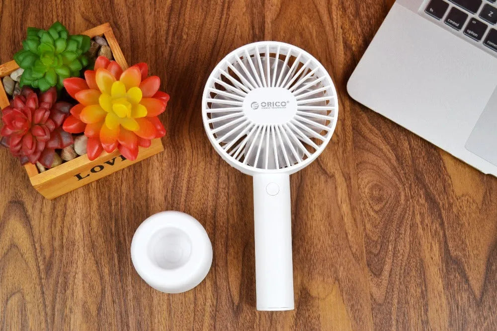 White ORICO FH1 portable USB desk fan with rechargeable battery on a wooden desk