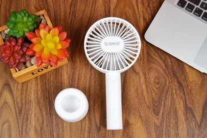 White ORICO FH1 portable USB desk fan with rechargeable battery on a wooden desk