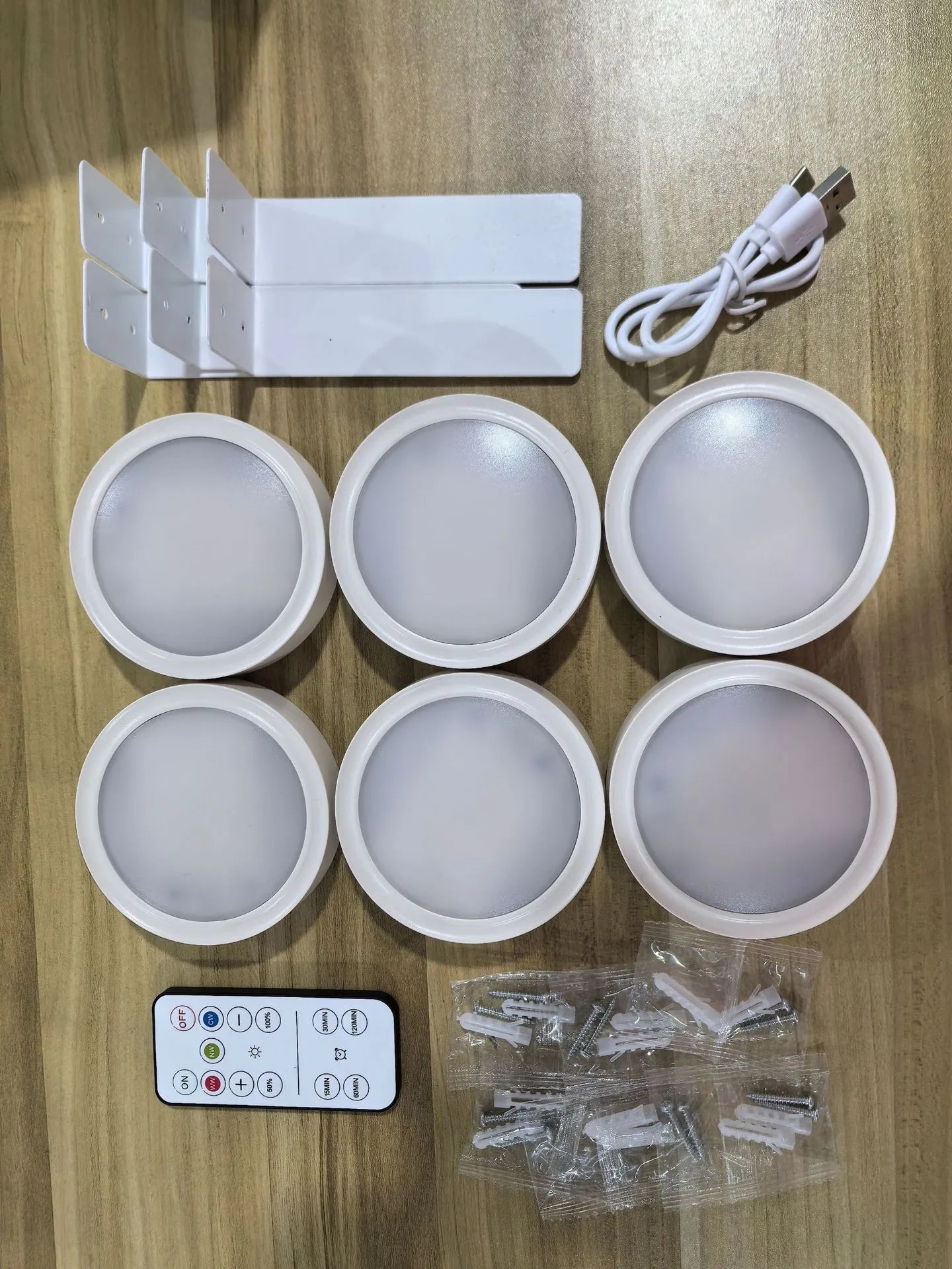 Black magnetic LED painting lamp with remote control on a white wall.