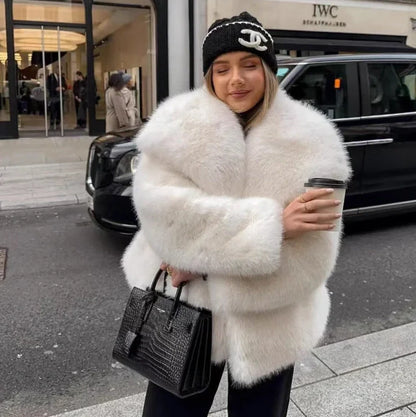 Women's white artificial fur coat with large lapel, long sleeves, and deep pockets shown in street fashion setting
