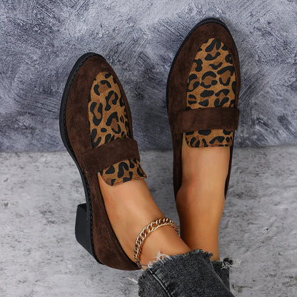 Leopard print slip-on suede pump shoe with chunky mid heel and pointed toe on a rubber sole.