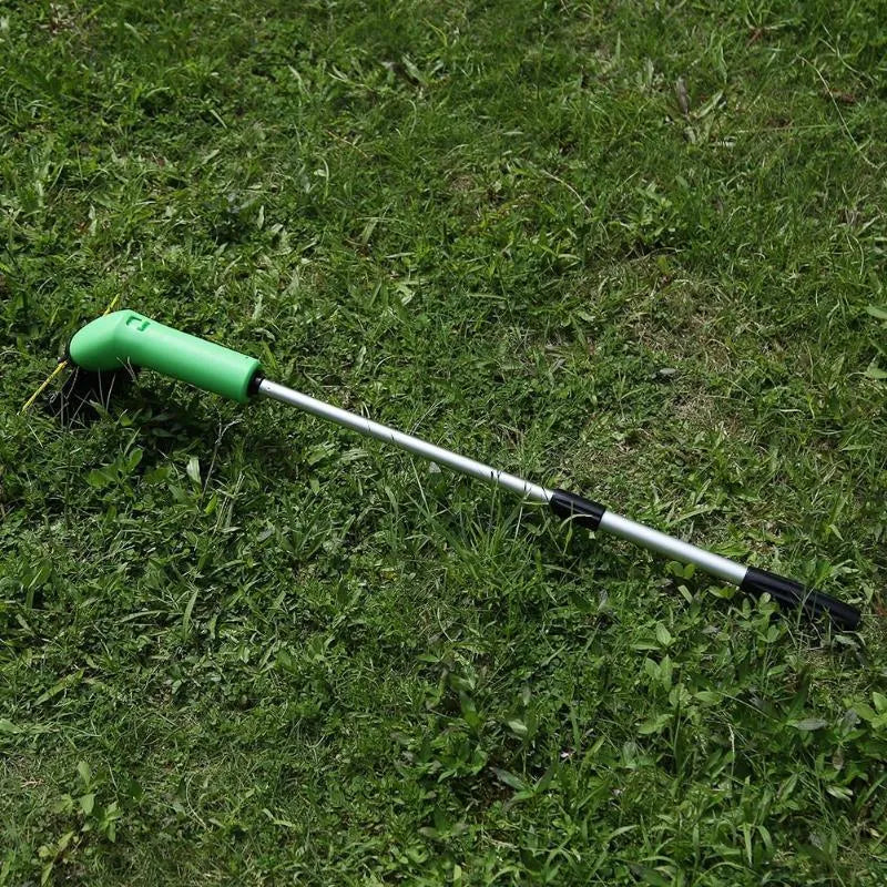 Cordless handheld lawn trimmer with green housing, extension pole, debris shield, and pack of zip ties on a garden lawn.