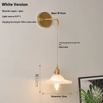 Retro brass lotus wall lamp with copper body and glass shade in various colours, mounted on a wall