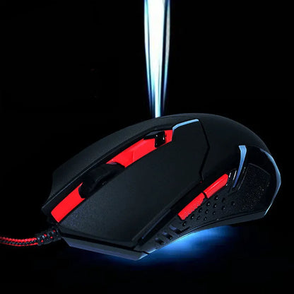 Black and red USB wired optical gaming mouse with six buttons on a desk.