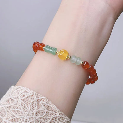 Close-up of a red agate bracelet featuring a detailed dragon design in a Chinese style.