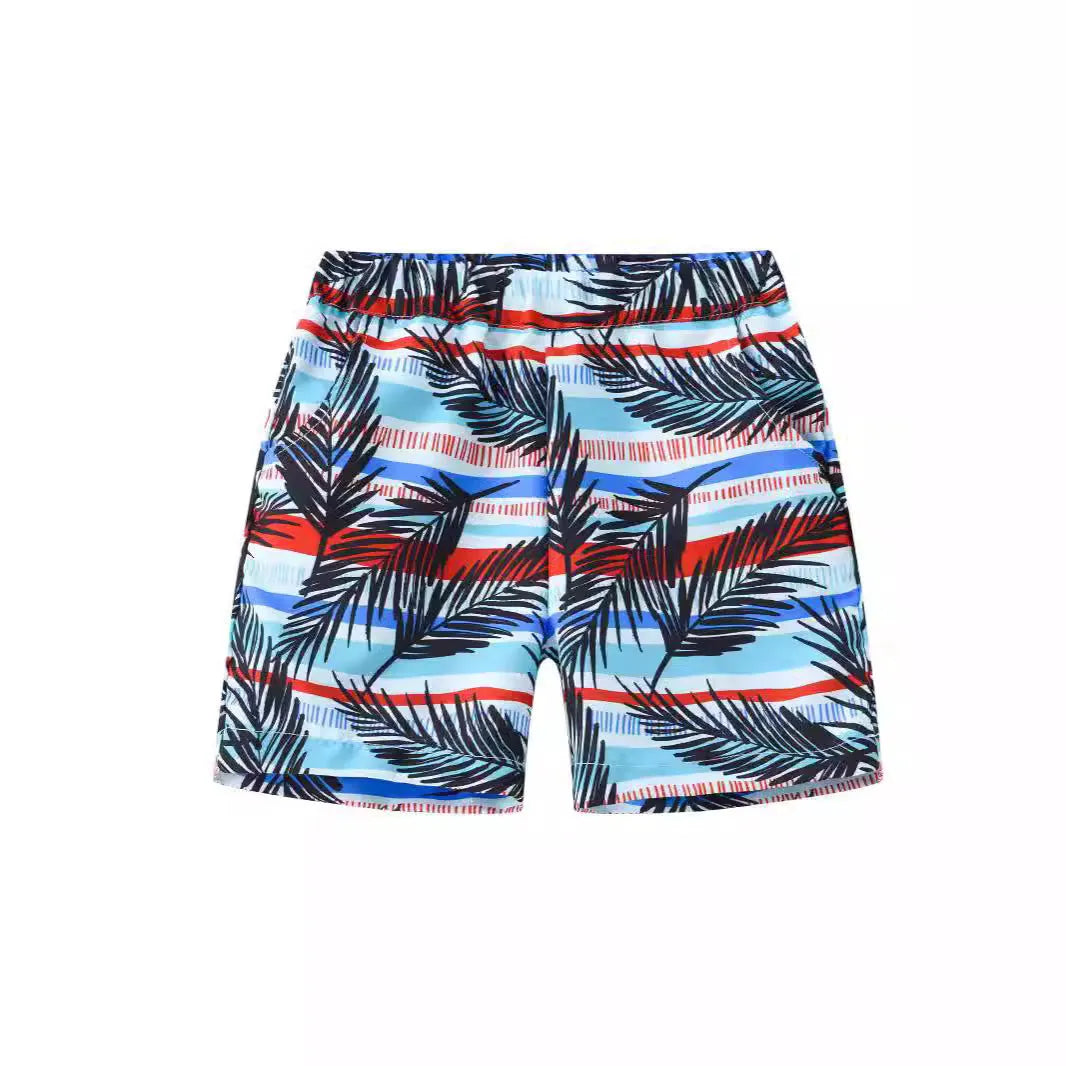 Colourful printed beach shorts with elastic waistband showing tropical patterns including coconut trees and pineapples
