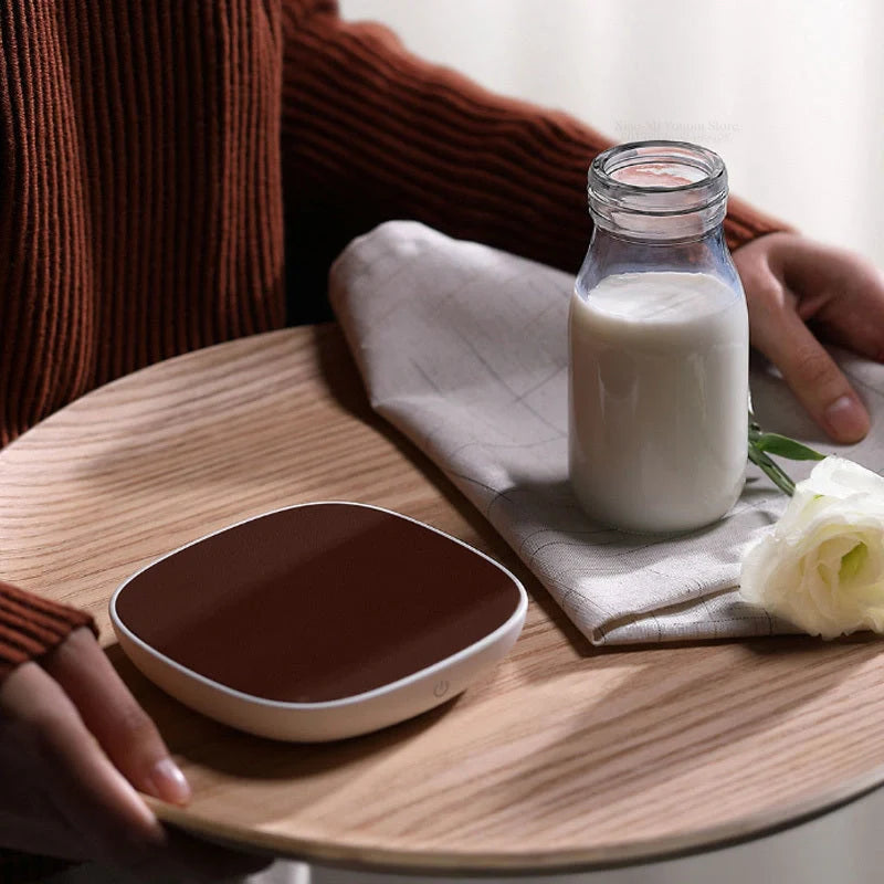 White 12V safety voltage heated base heating coaster on a wooden table