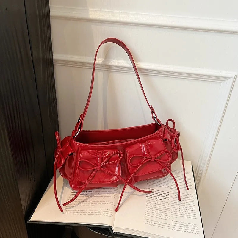 Women's tassel bow shoulder bag in pleated design with multiple pockets, shown in a selected colour.