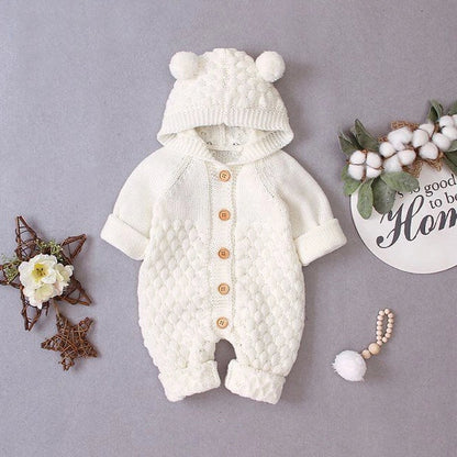 Baby wearing light blue knitted romper with hood and sleeveless design, single-breasted closure visible