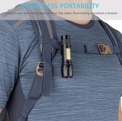 Black mini telescopic LED flashlight showing adjustable focus and pen-like design with clip attachment