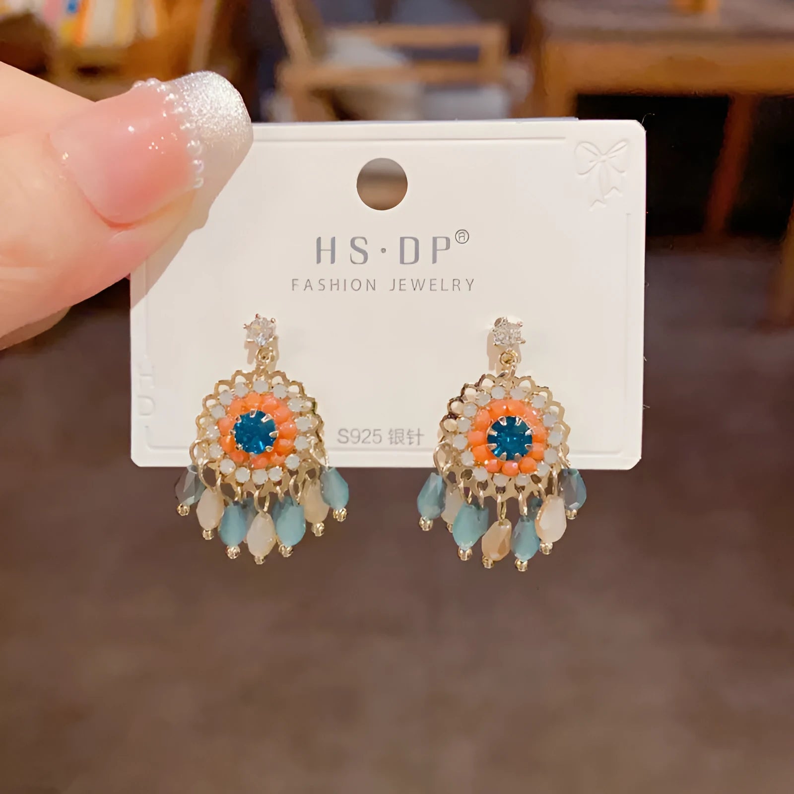 Gold plated geometric earrings with blue diamond-embedded crystals in tassel design