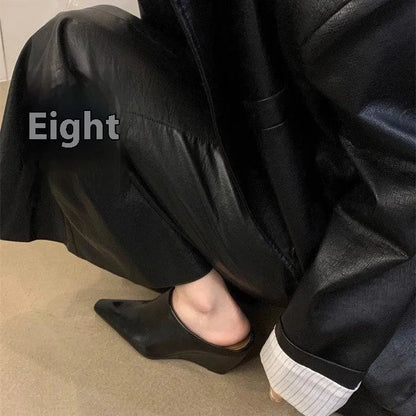 Women's black wind wedge closed toe half slippers on a plain background.