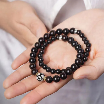 Dark ebony wood bracelet with Tibetan bead design showing two brown circles, 8mm wide unisex accessory