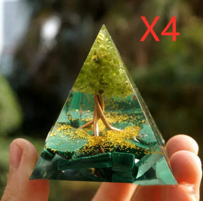 A small 6cm clear epoxy resin pyramid ornament containing pieces of natural crystal gravel on a flat surface.