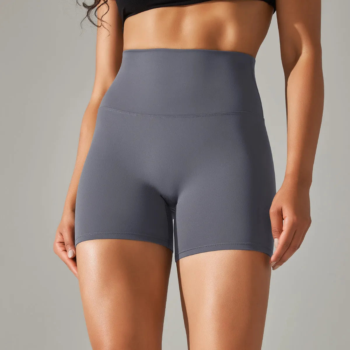 Woman wearing high waist hip lift fitness tights in a neutral colour, suitable for running or gym workout.
