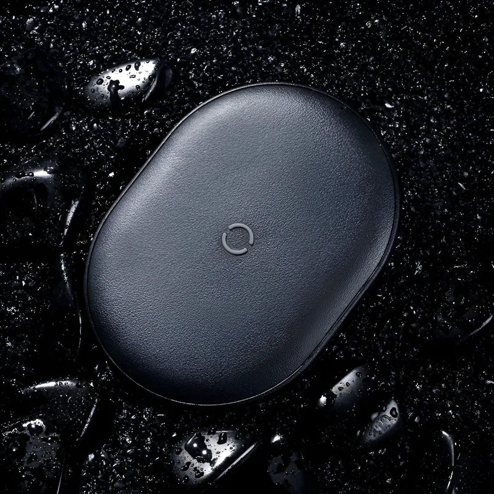 Black Baseus 15W wireless charging pad with textured silicone surface on a wooden desk.