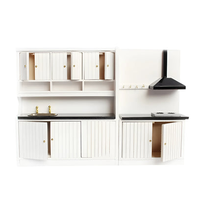 White two-piece dollhouse kitchen cabinet set with sink and stove units on a table.