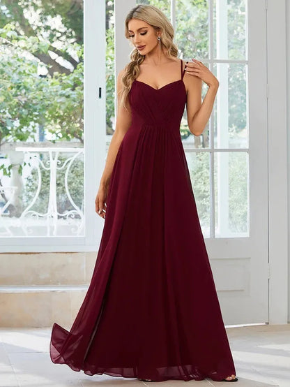 Women's sleeveless long dress with sling neckline and pleated A-line skirt in a solid colour.