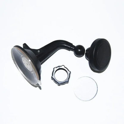 Classic black magnetic car phone holder mounted on a car dashboard, showing a smartphone attached.