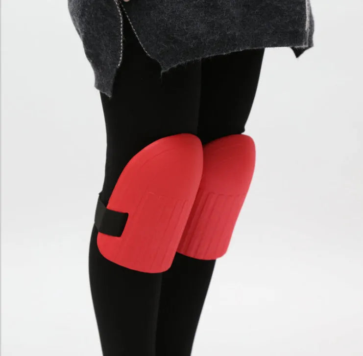 A pair of rectangular EVA foam knee pads in army green colour, placed on a garden soil background.