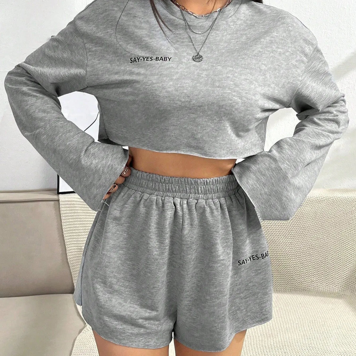 Grey women's long-sleeved T-shirt and shorts polyester set laid flat