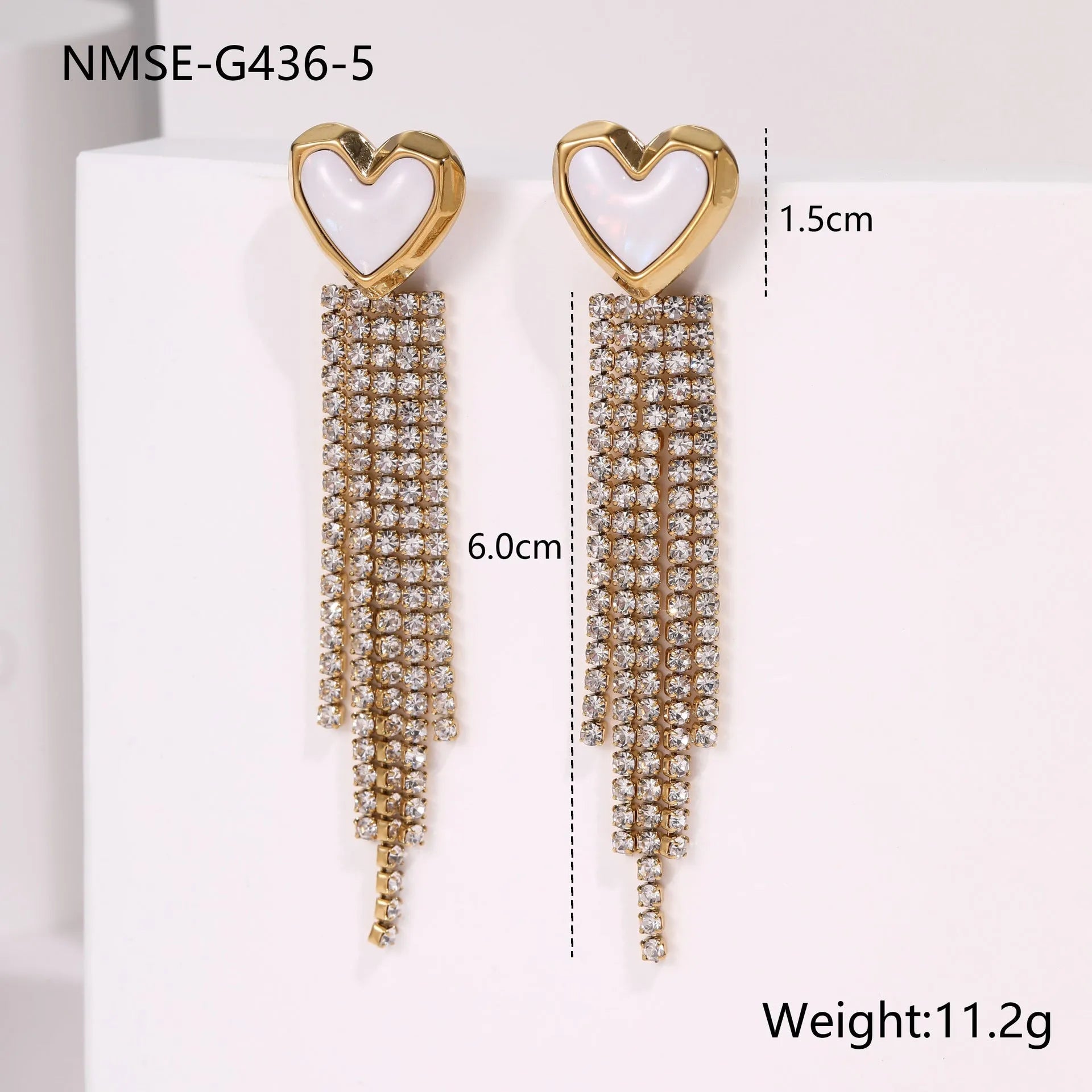 Gold-coloured women's earrings with a love heart shape, star details and dangling diamond-style tassels on a white background.