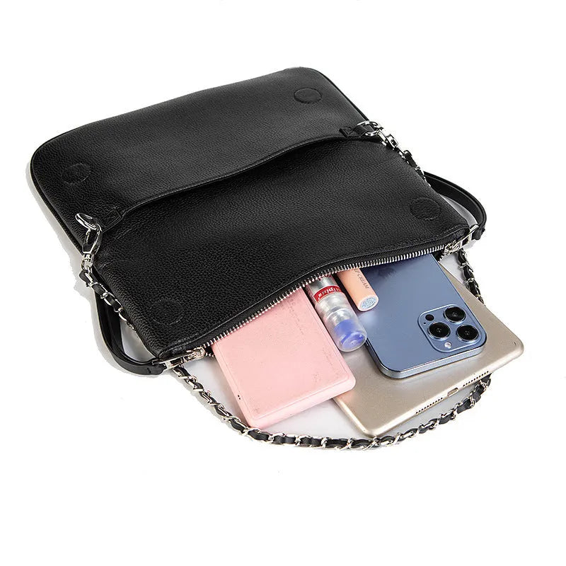 Soft black PU leather women's clutch bag with a gold chain strap, shown held and worn cross-body.