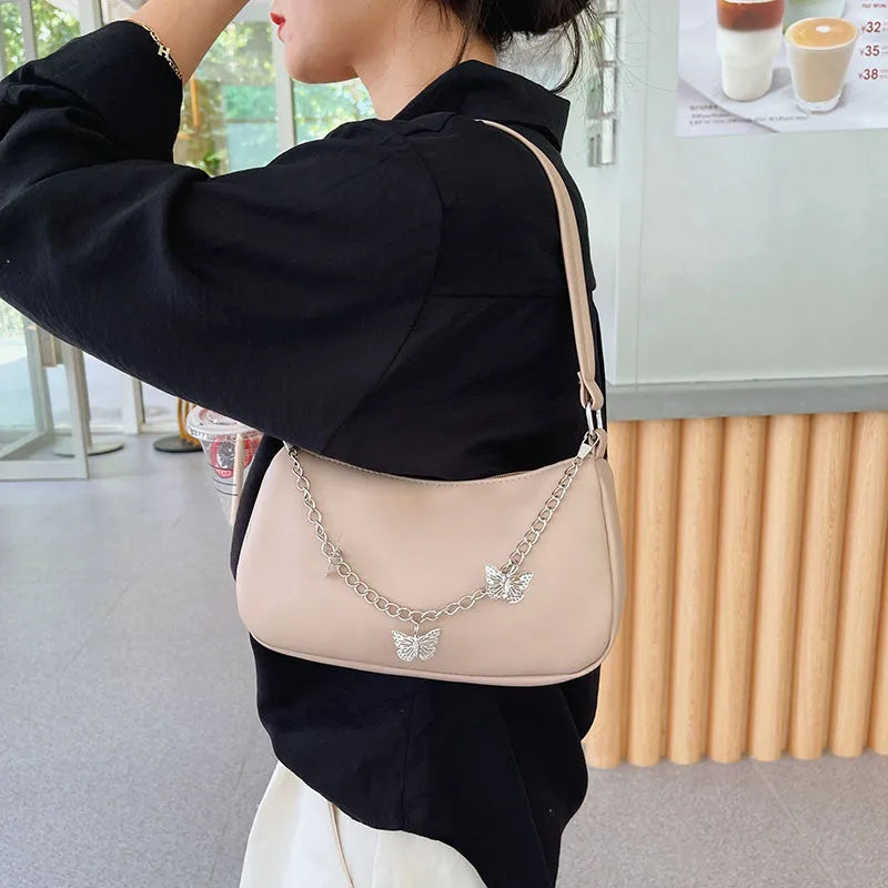 Women's black PU leather chain crossbody bag with butterfly clasp and structured square silhouette