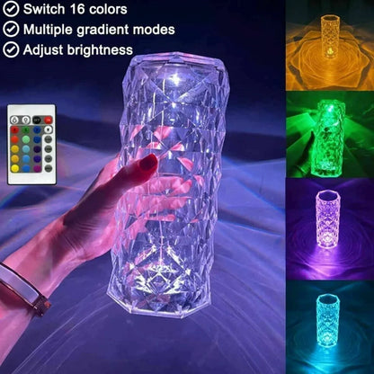 Clear acrylic LED table lamp with diamond-cut surfaces and remote control on wooden surface