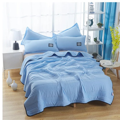Lightweight plain coloured polyester summer quilt on a bed