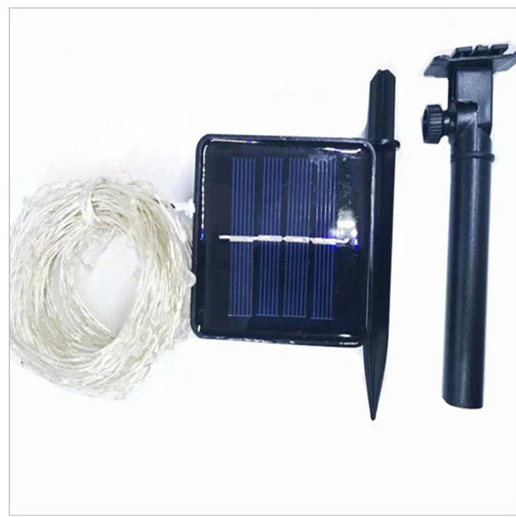 Solar-powered LED string lights arranged in garden with solar panel charging in sunlight