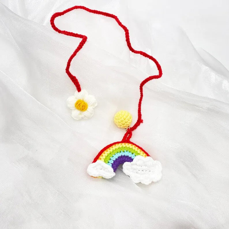 Handmade crocheted cartoon-style car pendant in wool, shown in avocado, pink rainbow, and red rainbow colour options.