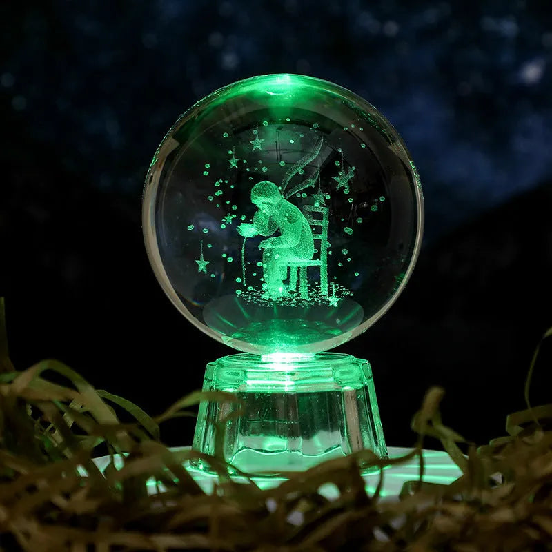 Transparent crystal ball ornament with inner carving of clouds, shown on a wooden table.