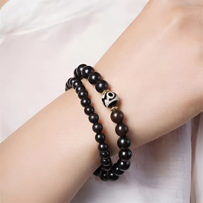 Dark ebony wood bracelet with Tibetan bead design showing two brown circles, 8mm wide unisex accessory