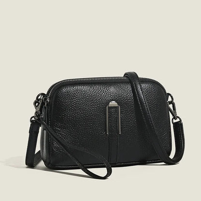 Women's genuine leather square shoulder bag in black, shown from front, displaying structured horizontal shape.