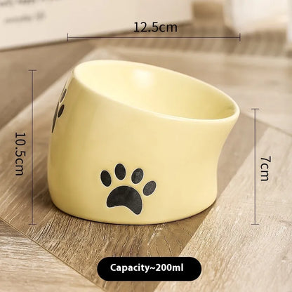 Ceramic cat bowl with high foot and cat's paw base in an oblique mouth design.