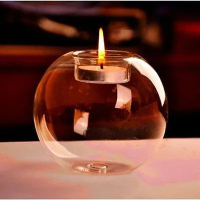 Handmade round hollow glass candle holder in three sizes on a table.