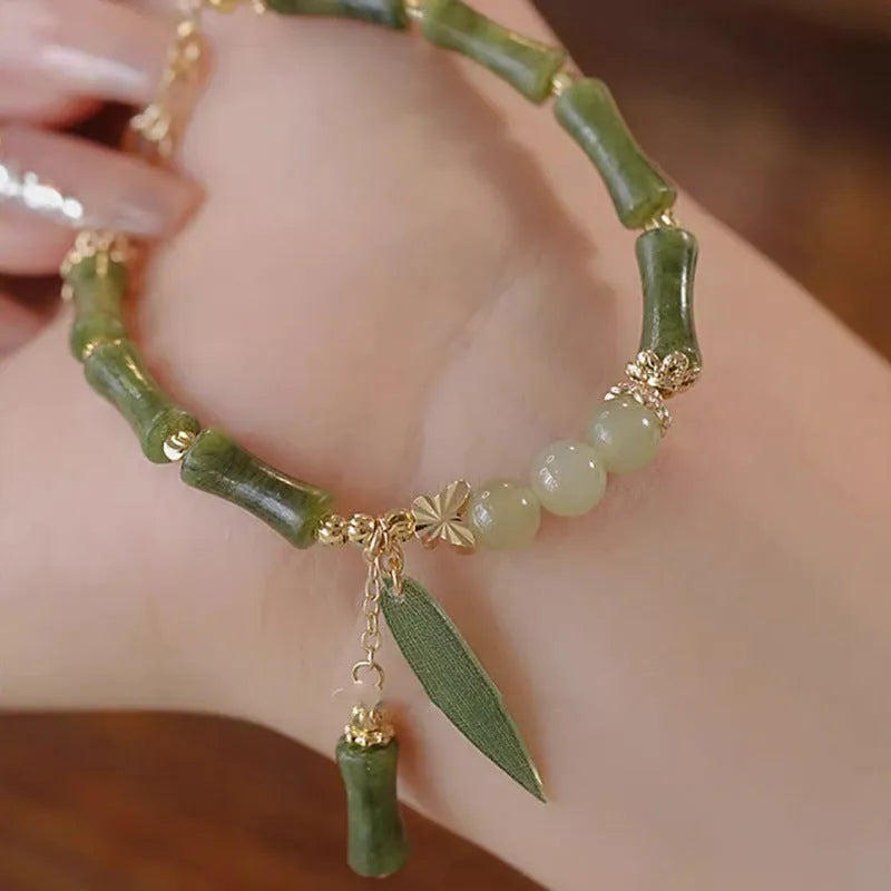 Chinese style glass bead bracelet with bamboo joint design on wrist.