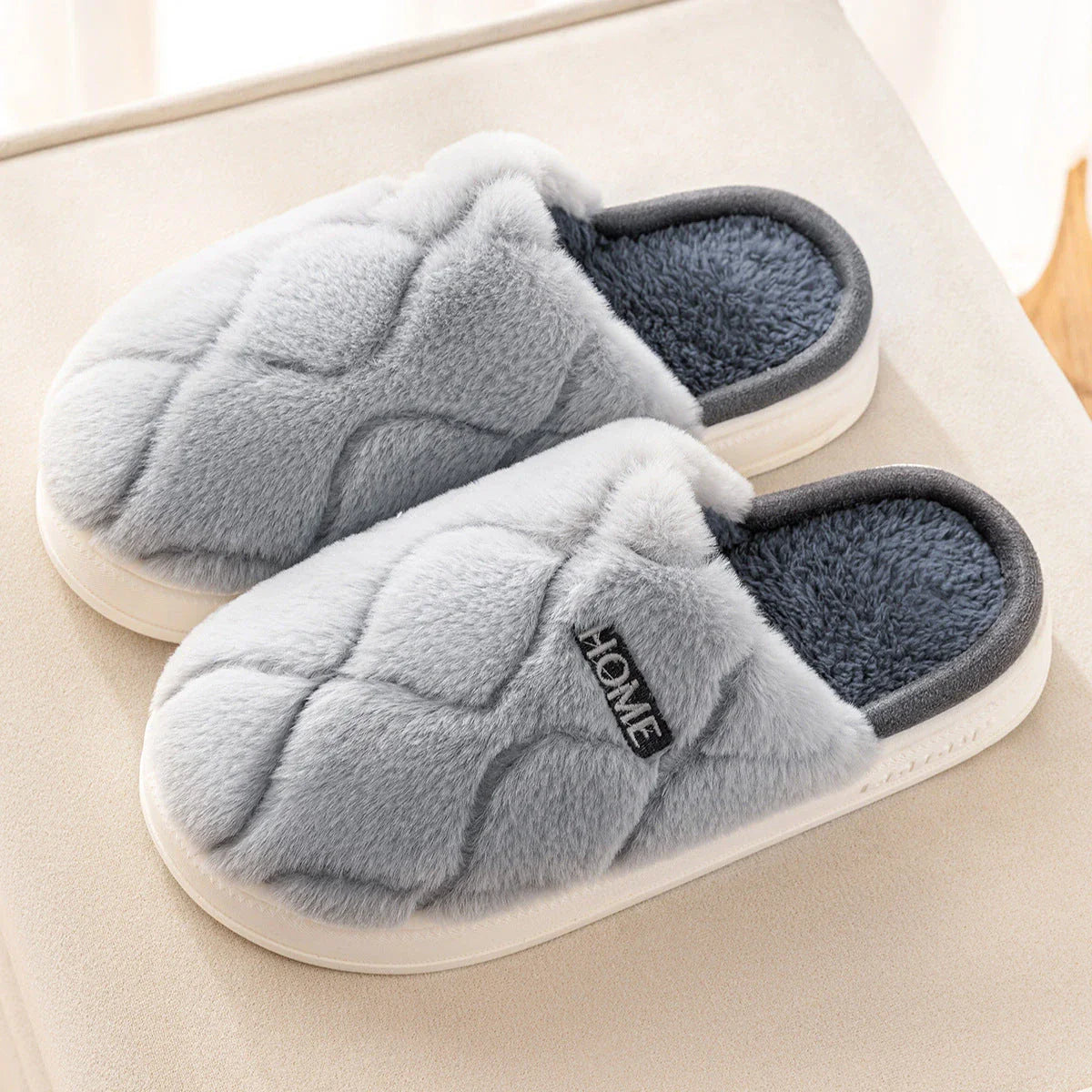 Cozy plush slippers in various colors, including light gray, khaki, yellow, and pink, with a soft plush upper and durable PVC sole for indoor and outdoor use.