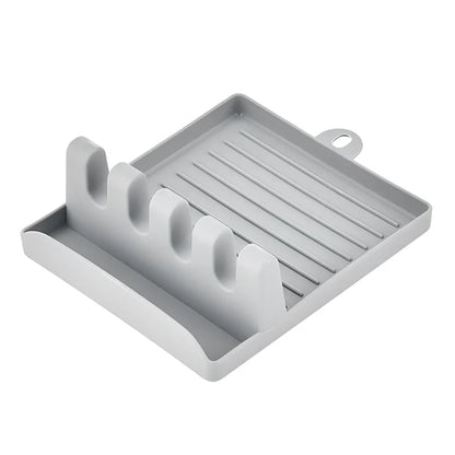 Green silicone spatula holder with four slots for kitchen utensils on countertop