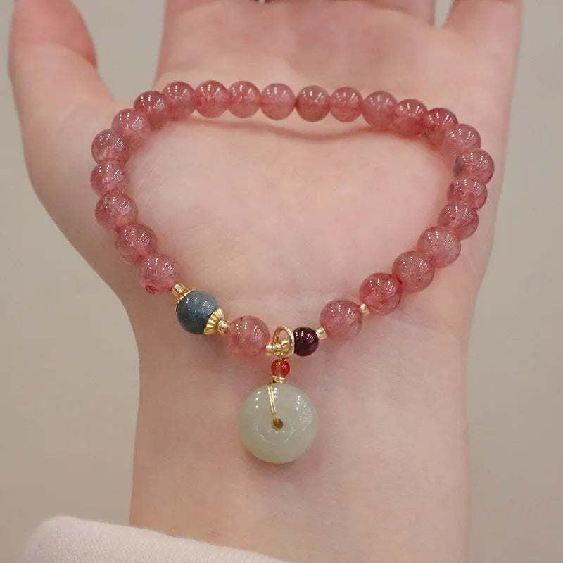 Women's strawberry quartz bracelet with geometric design and decorative purse charm on safety buckle closure