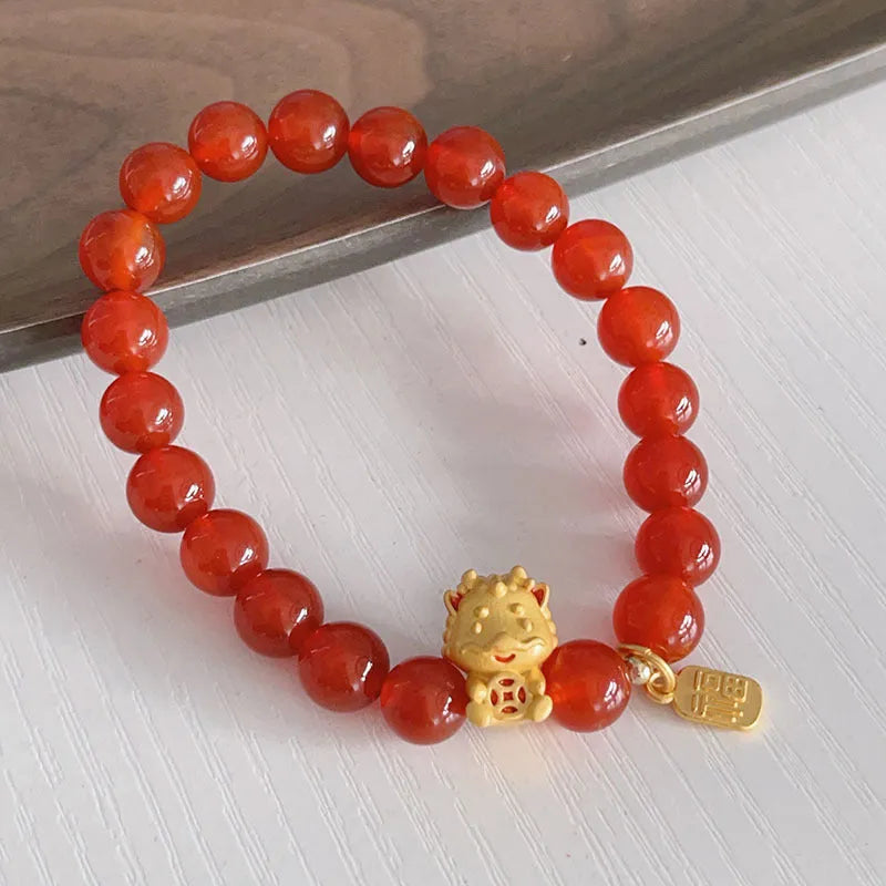 Close-up of a red agate bracelet featuring a detailed dragon design in a Chinese style.